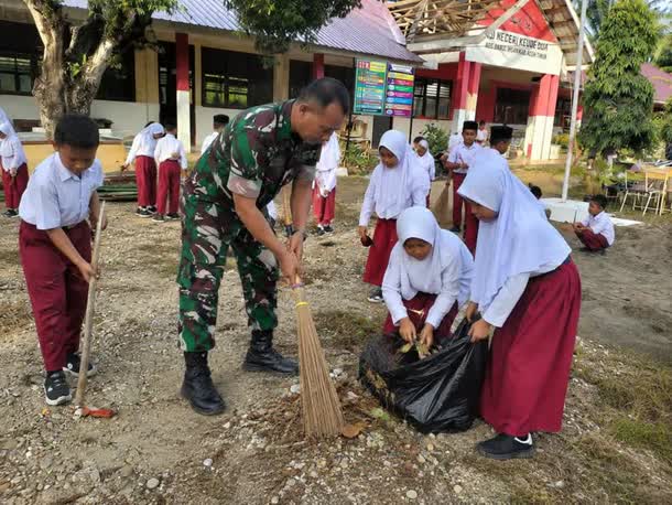 Babinsa Ajak Siswa SDN Keude Dua Bersihkan Lingkungan Sekolah